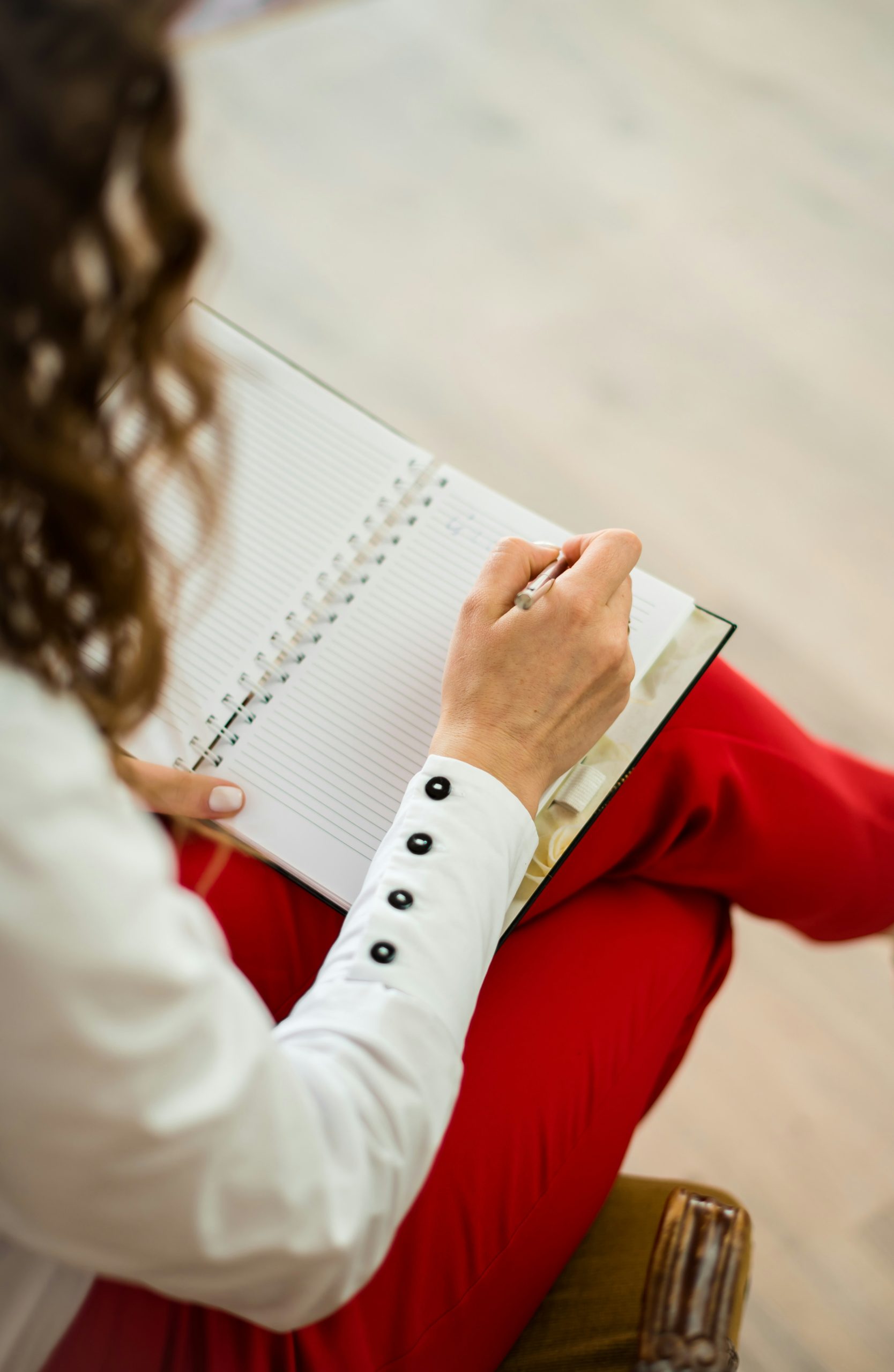 Mujer sentada con las piernas cruzadas escribiendo en un cuaderno