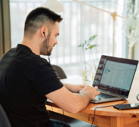 Hombre sentado tomando clases en linea desde su pc