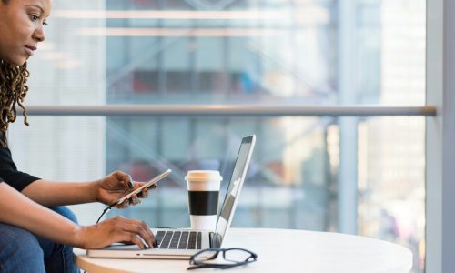 Mujer sentada, buscando licenciaturas online en su computadora