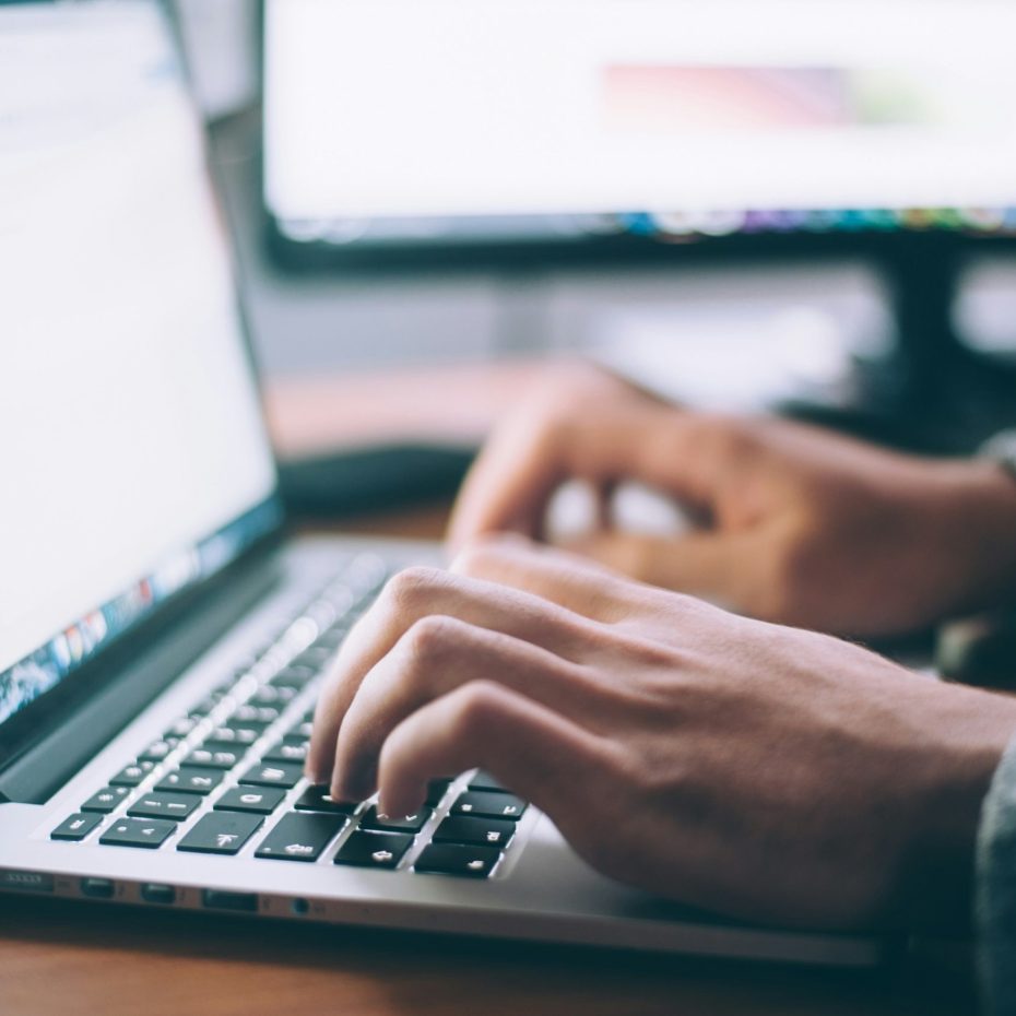 Manos de una persona escribiendo en el teclado de una computadora